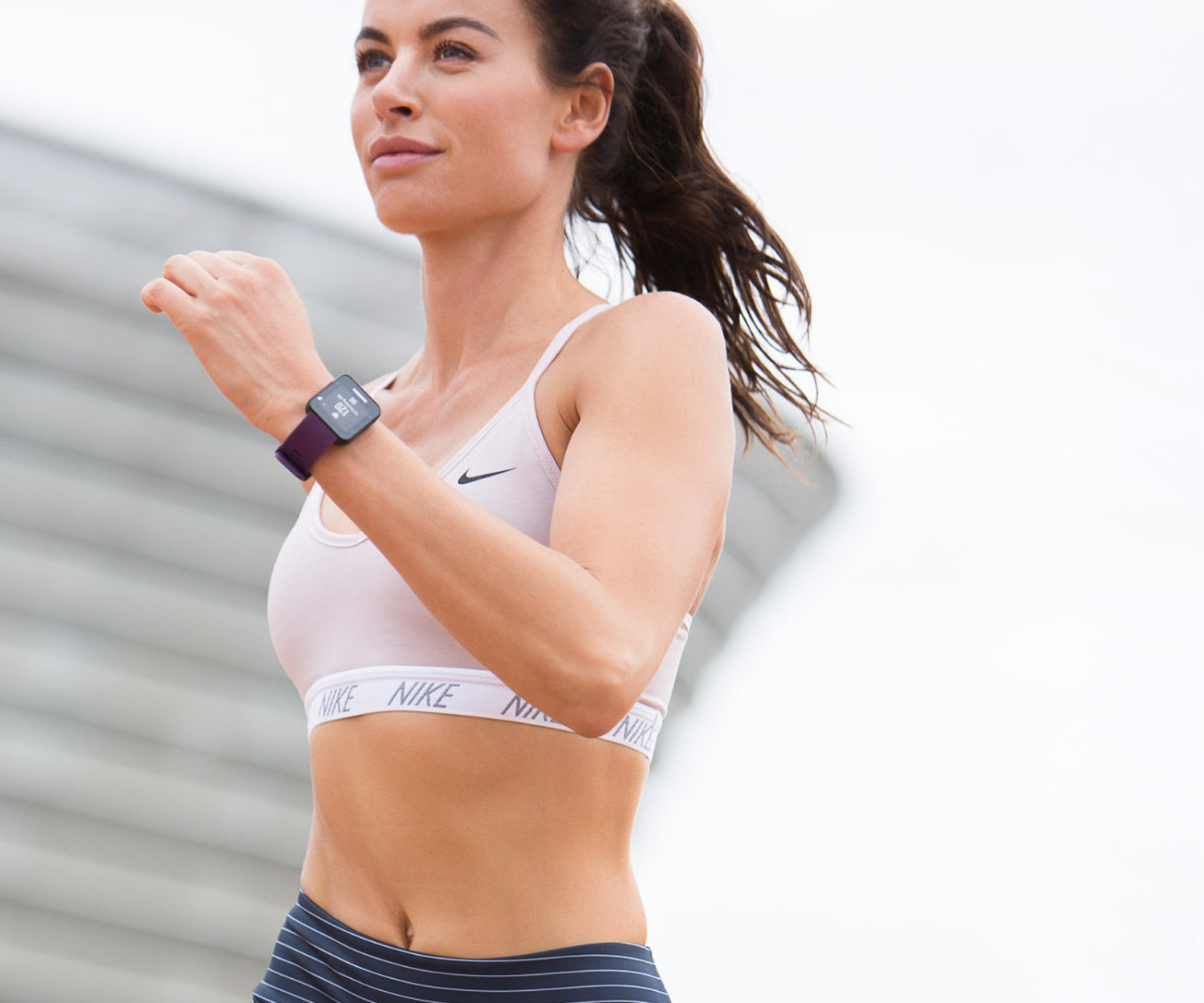 Woman running outdoors wearing a smart watch