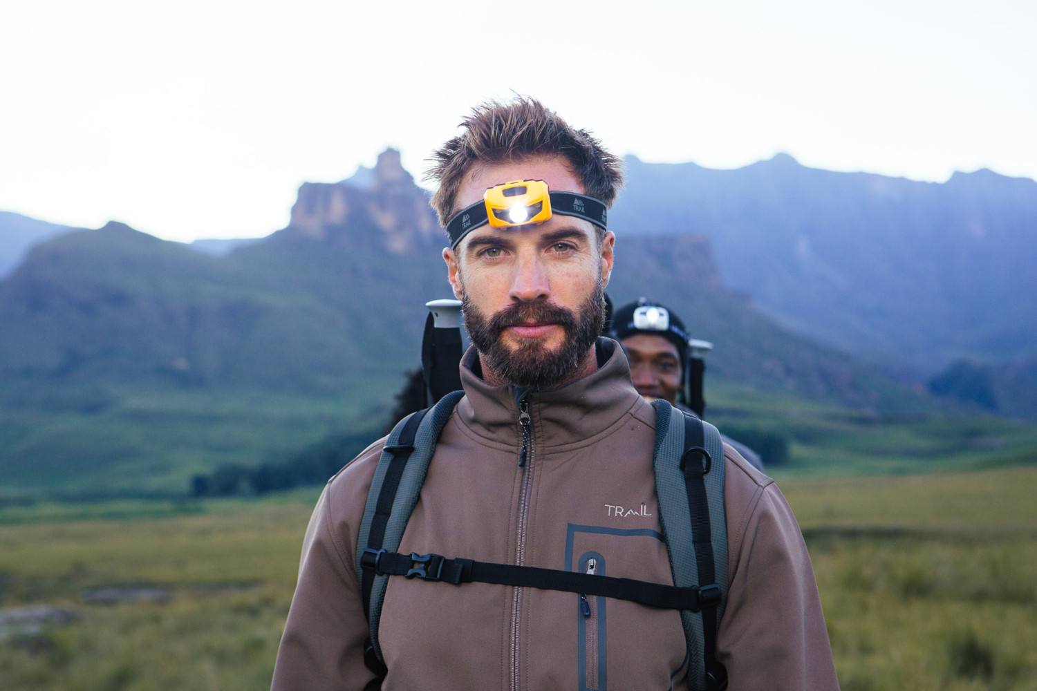 Man hiking in mountains wearing headlamp gear