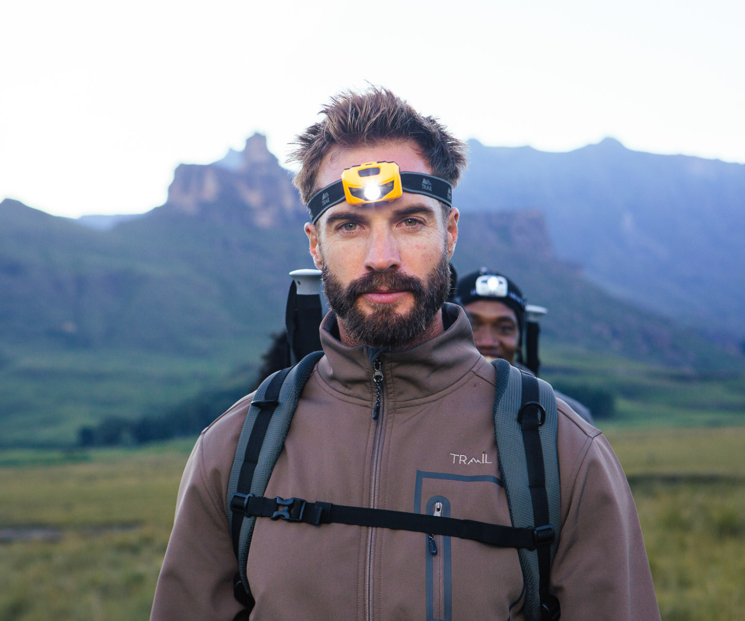 Man hiking in mountains wearing headlamp gear