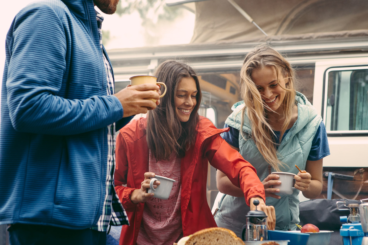People enjoying a cozy outdoor camping breakfast