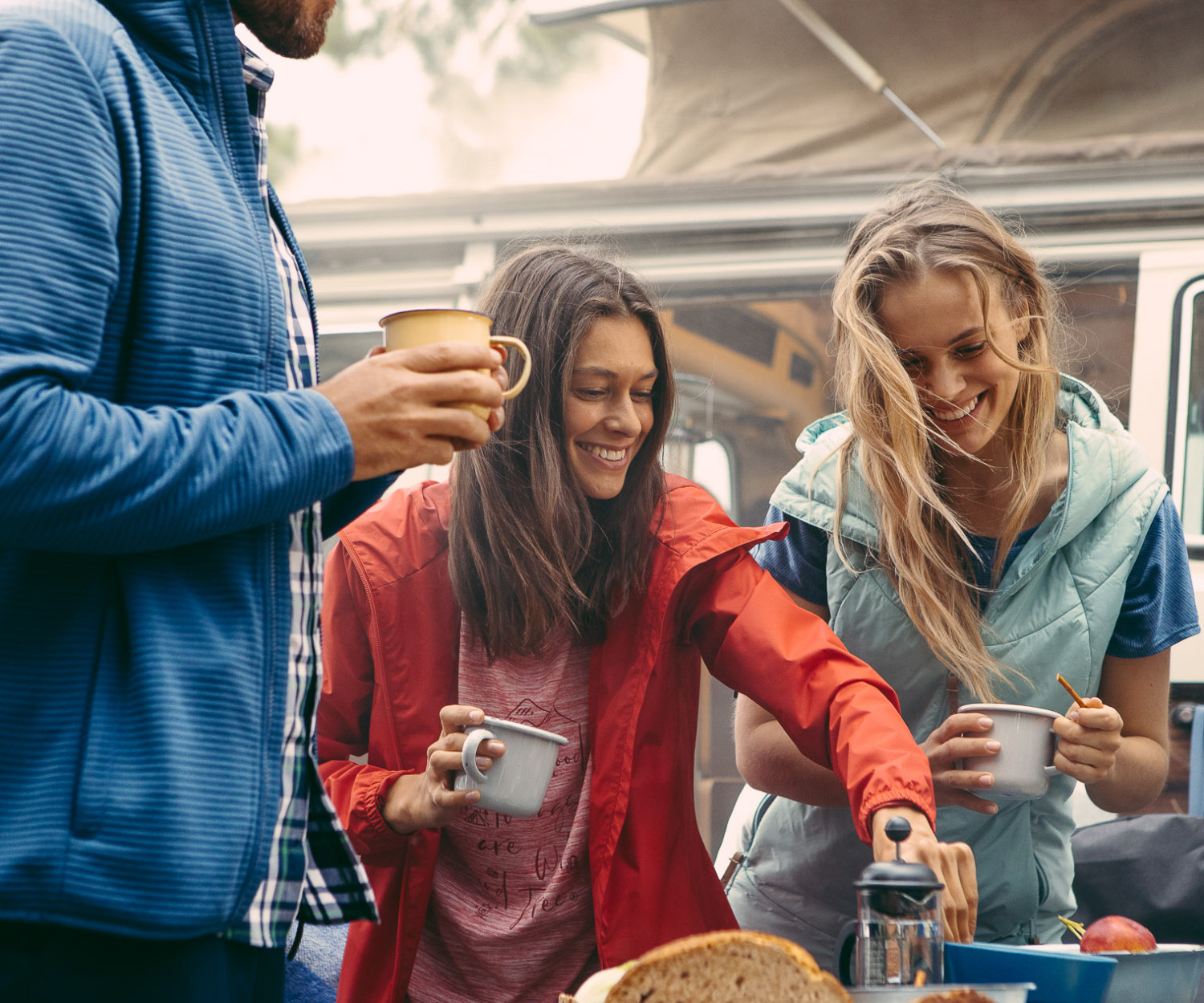 People enjoying a cozy outdoor camping breakfast