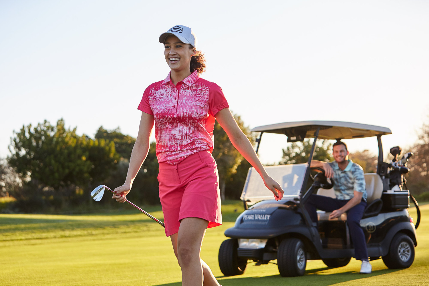 Woman playing golf with a golf cart