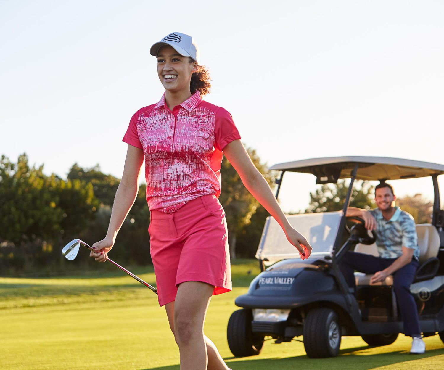 Woman playing golf with a golf cart