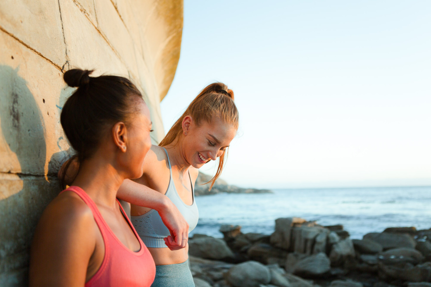 Two women enjoying a sunny coastal view