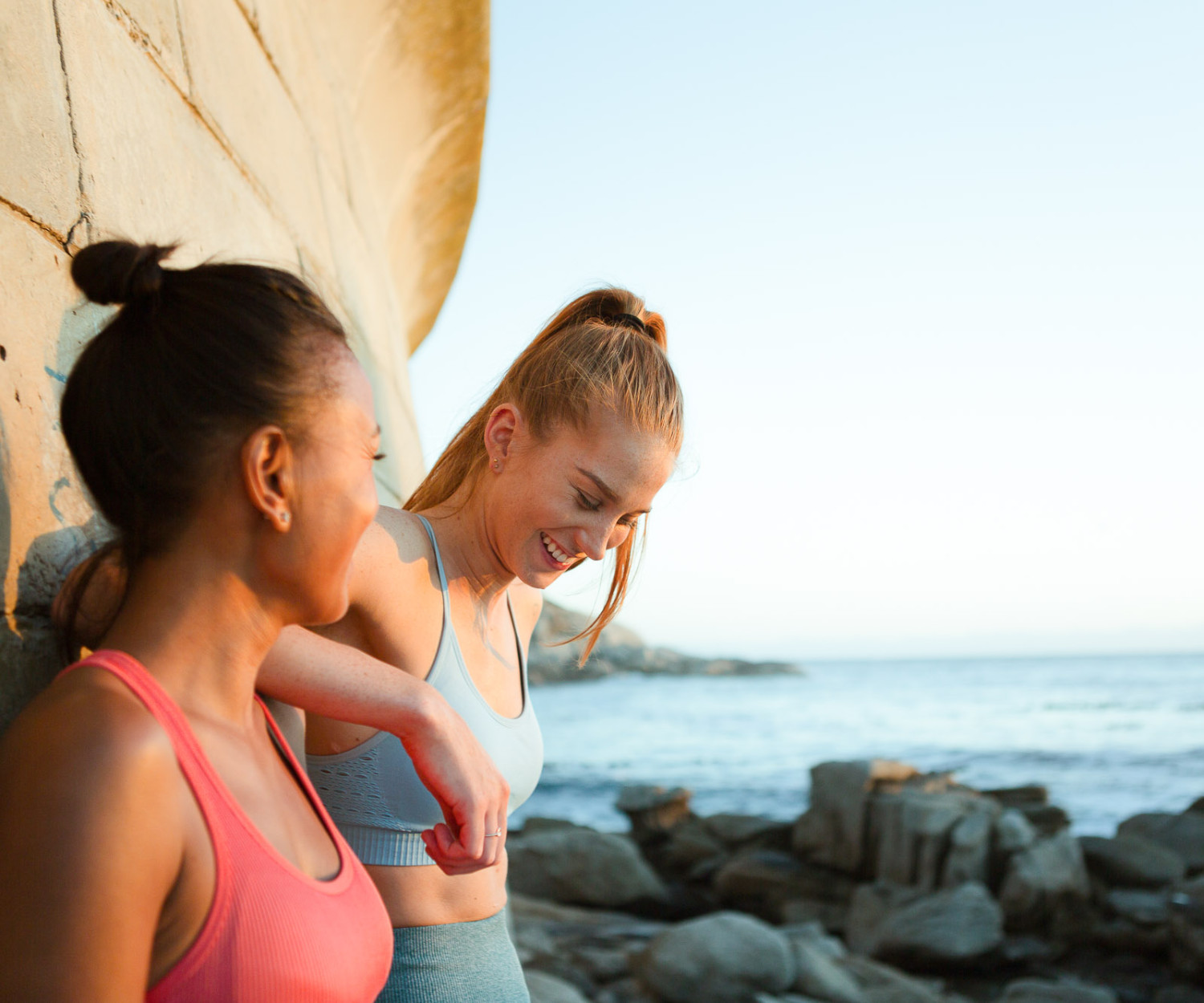 Two women enjoying a sunny coastal view