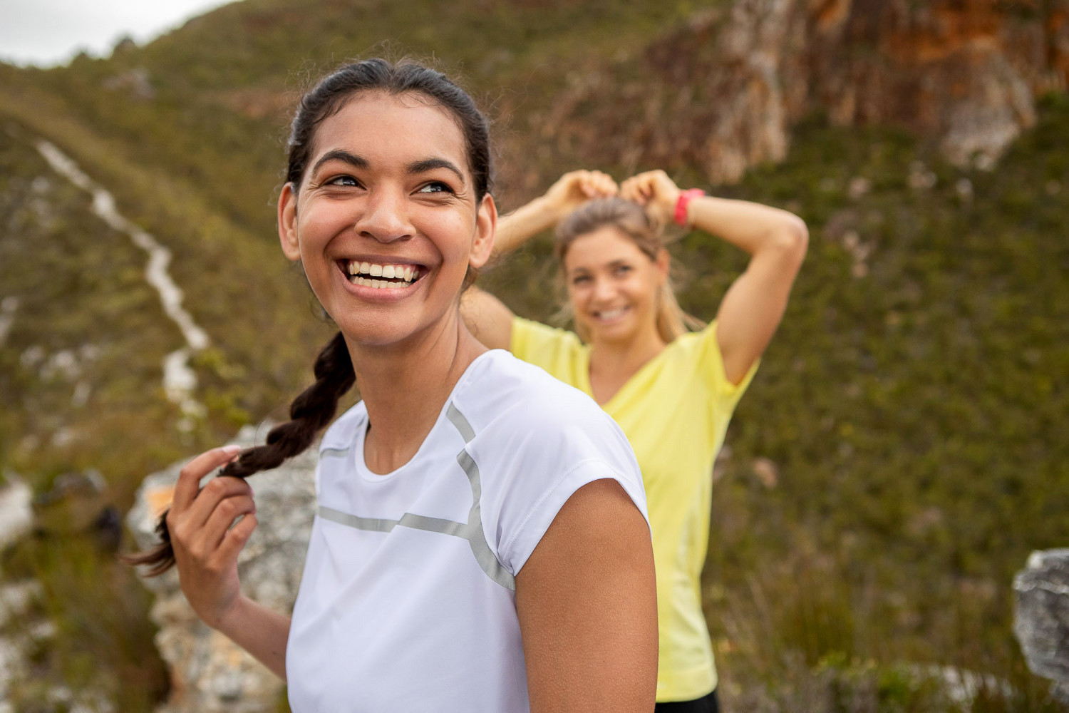 Two women smiling while hiking in nature