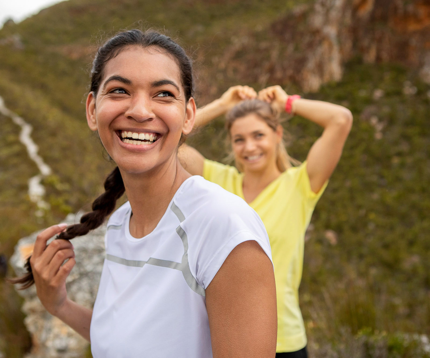 Two women smiling while hiking in nature