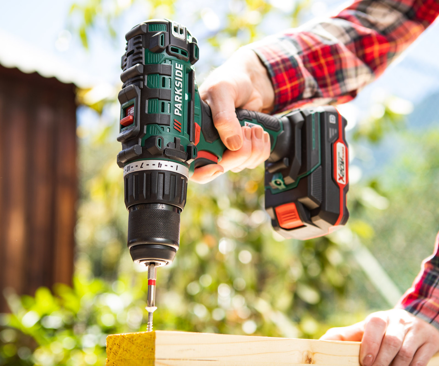 Person using cordless drill on wooden plank