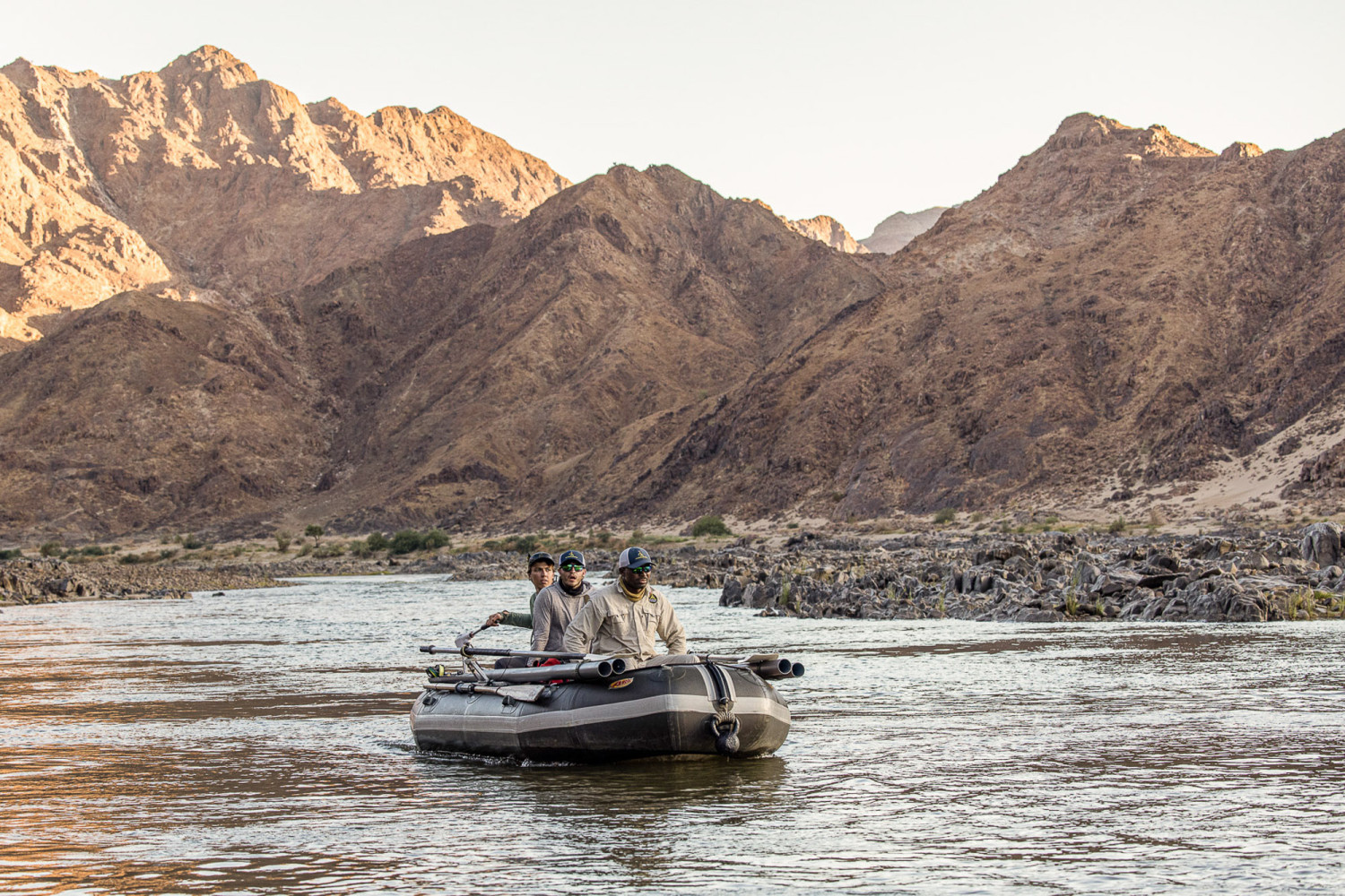 Mavungana Flyfishing on the Orange River. Raft fly fishing with mountains in background. Adventure travel.