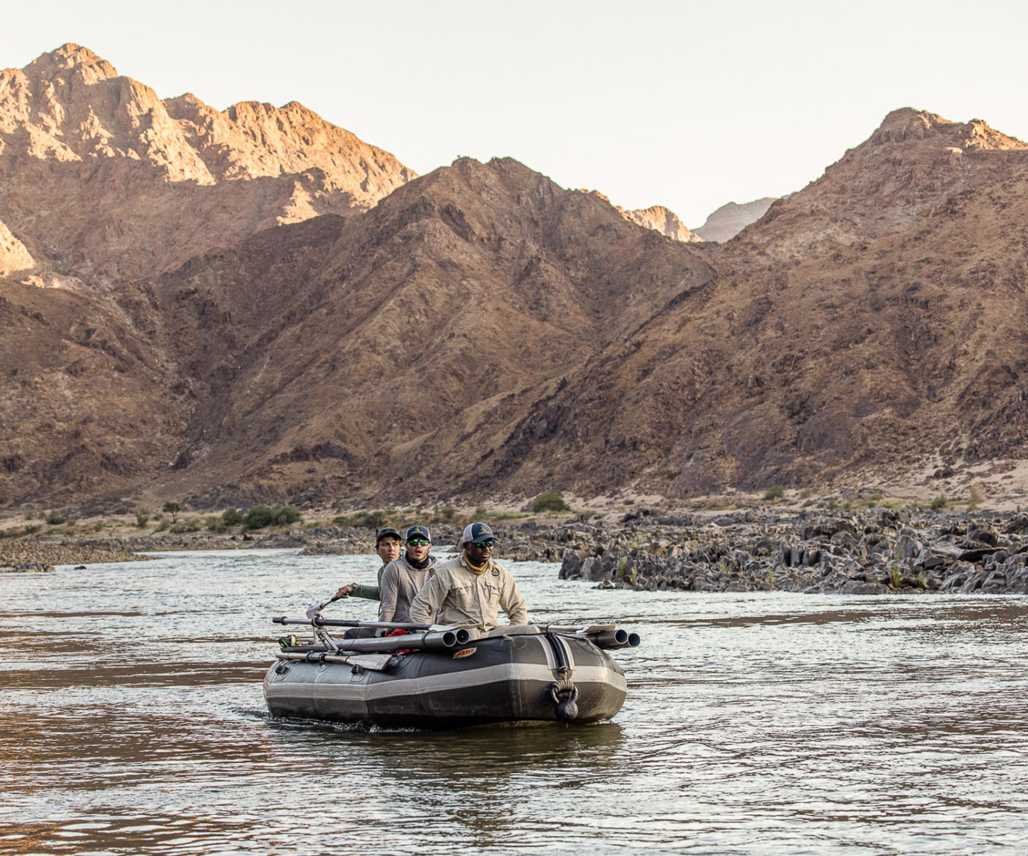 Mavungana Flyfishing on the Orange River. Raft fly fishing with mountains in background. Adventure travel.