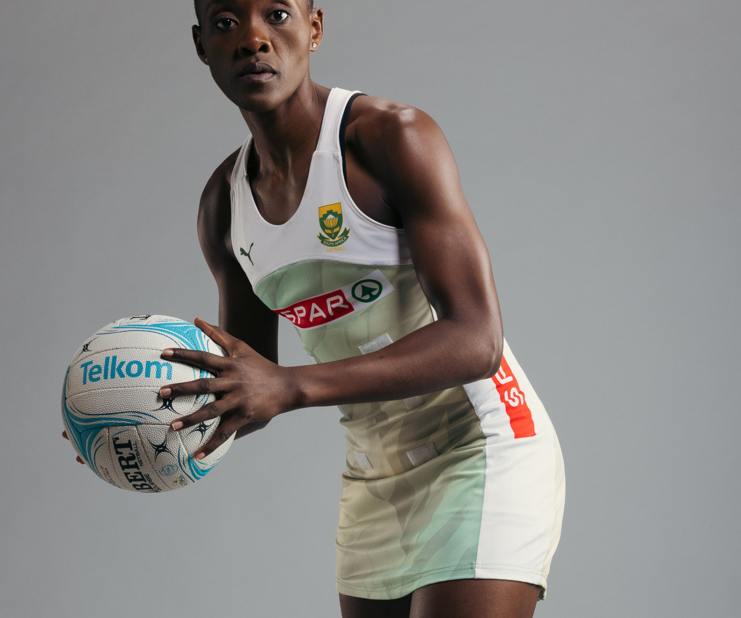 Netball player poised holding a Telkom ball