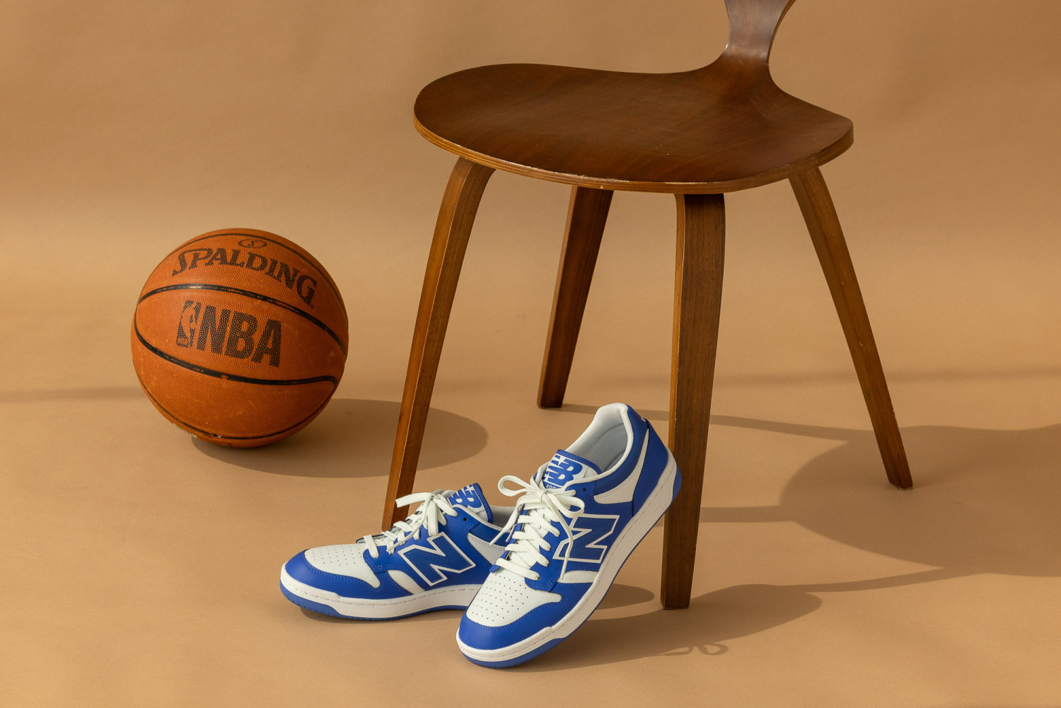 Blue sneakers next to basketball and chair