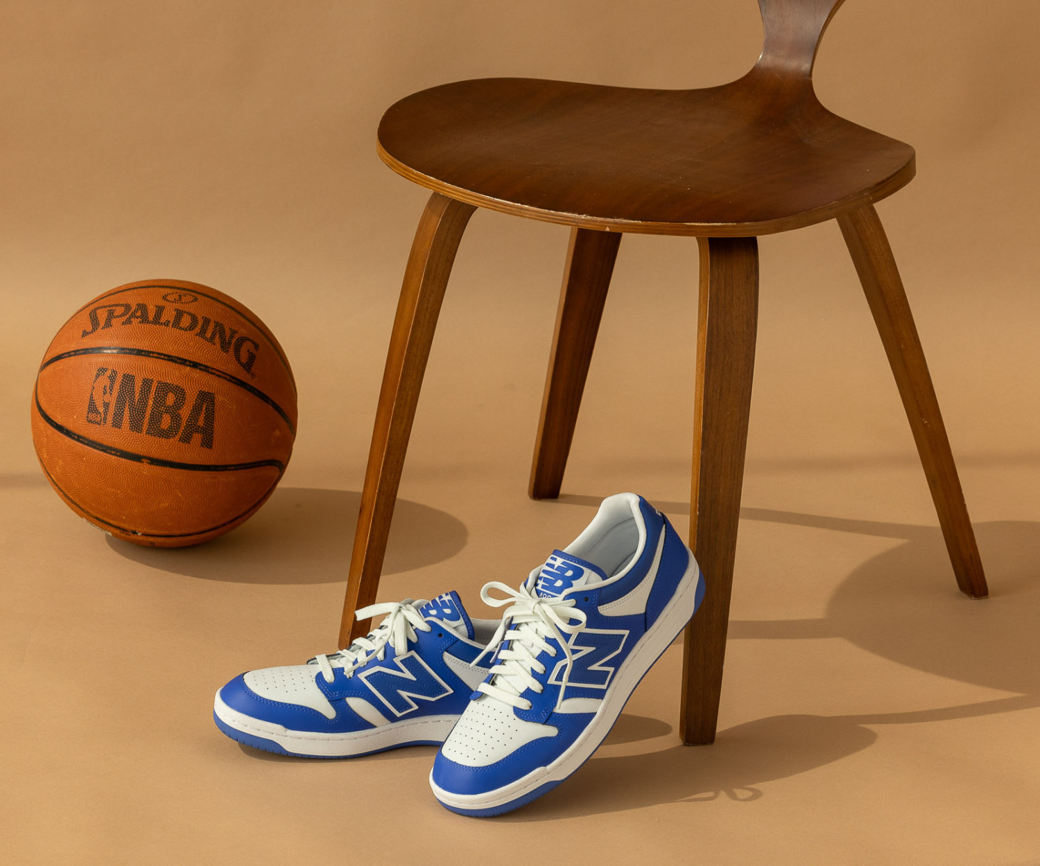 Blue sneakers next to basketball and chair