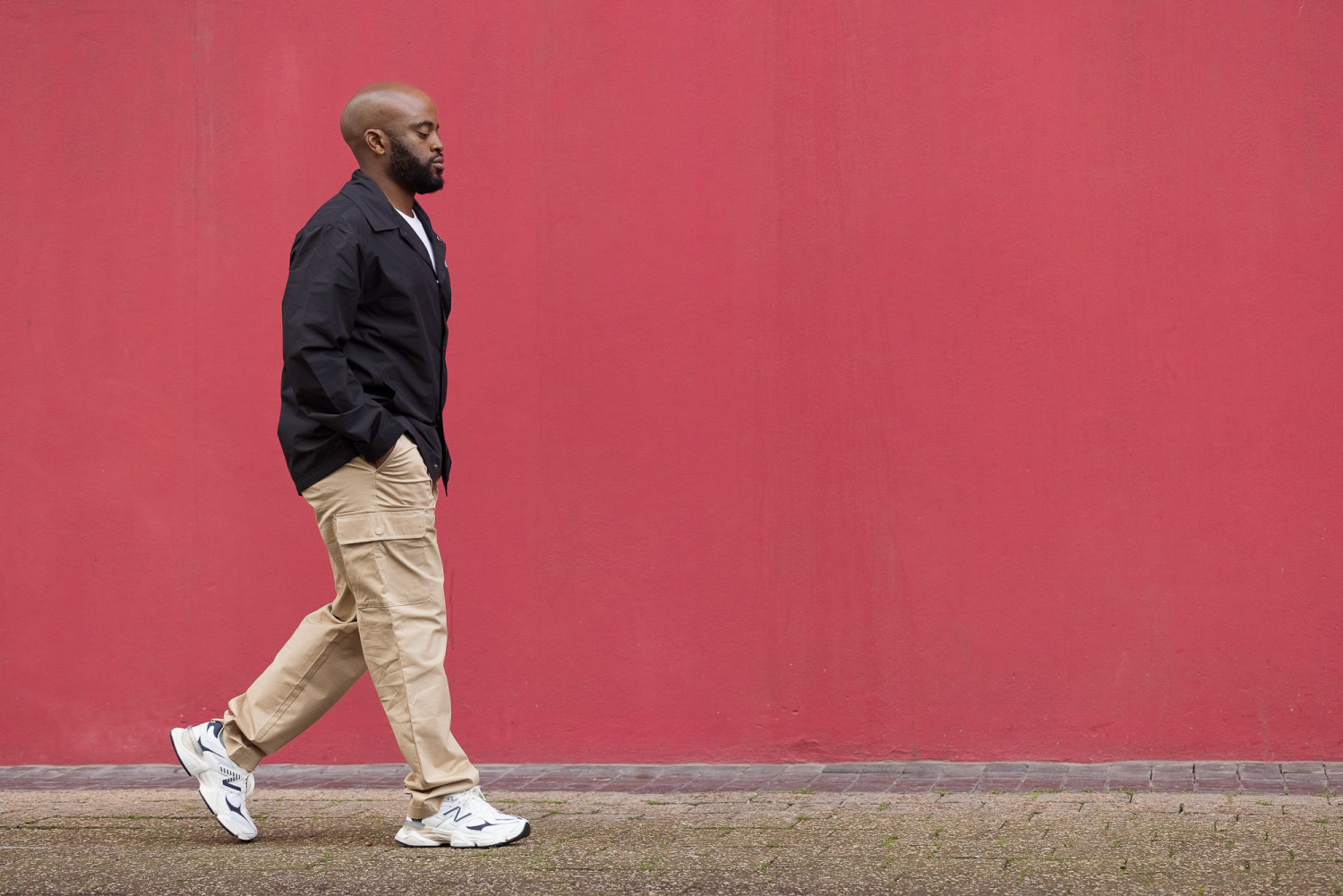 Man walking by a vibrant red wall