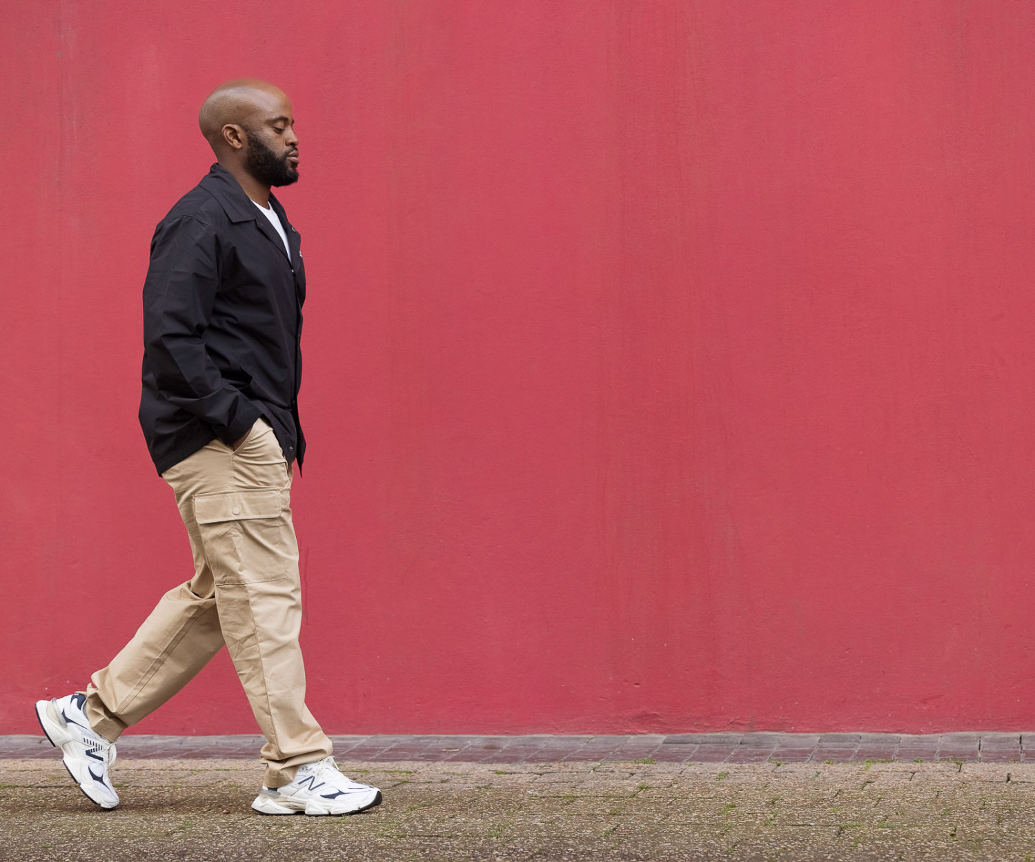 Man walking by a vibrant red wall