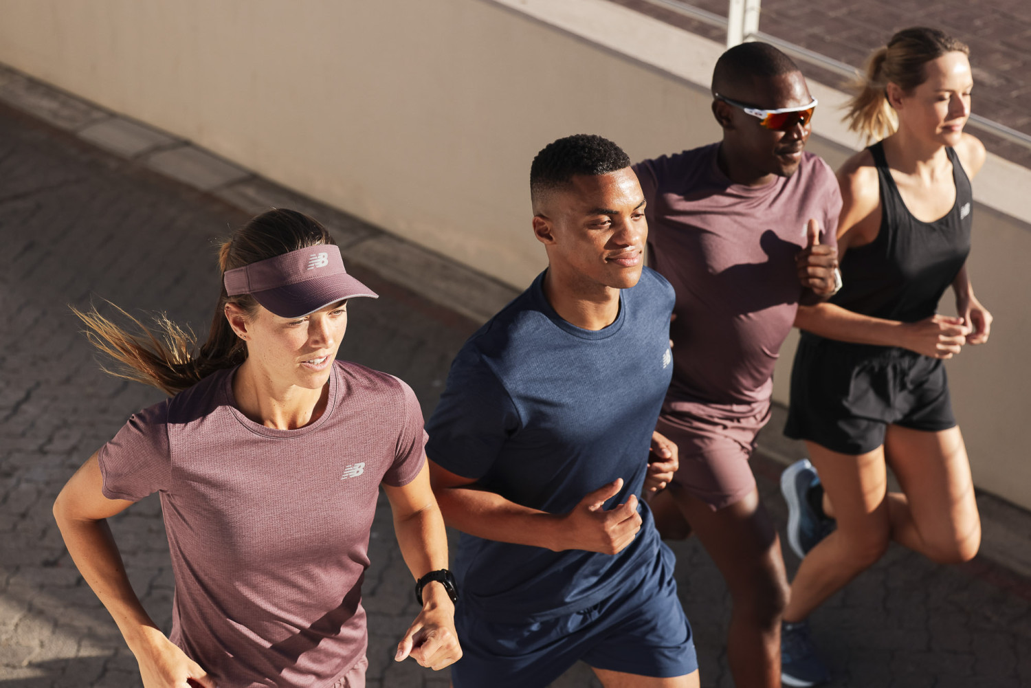 Group of four people jogging outdoors together
