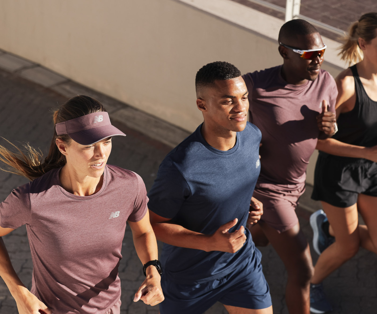 Group of four people jogging outdoors together