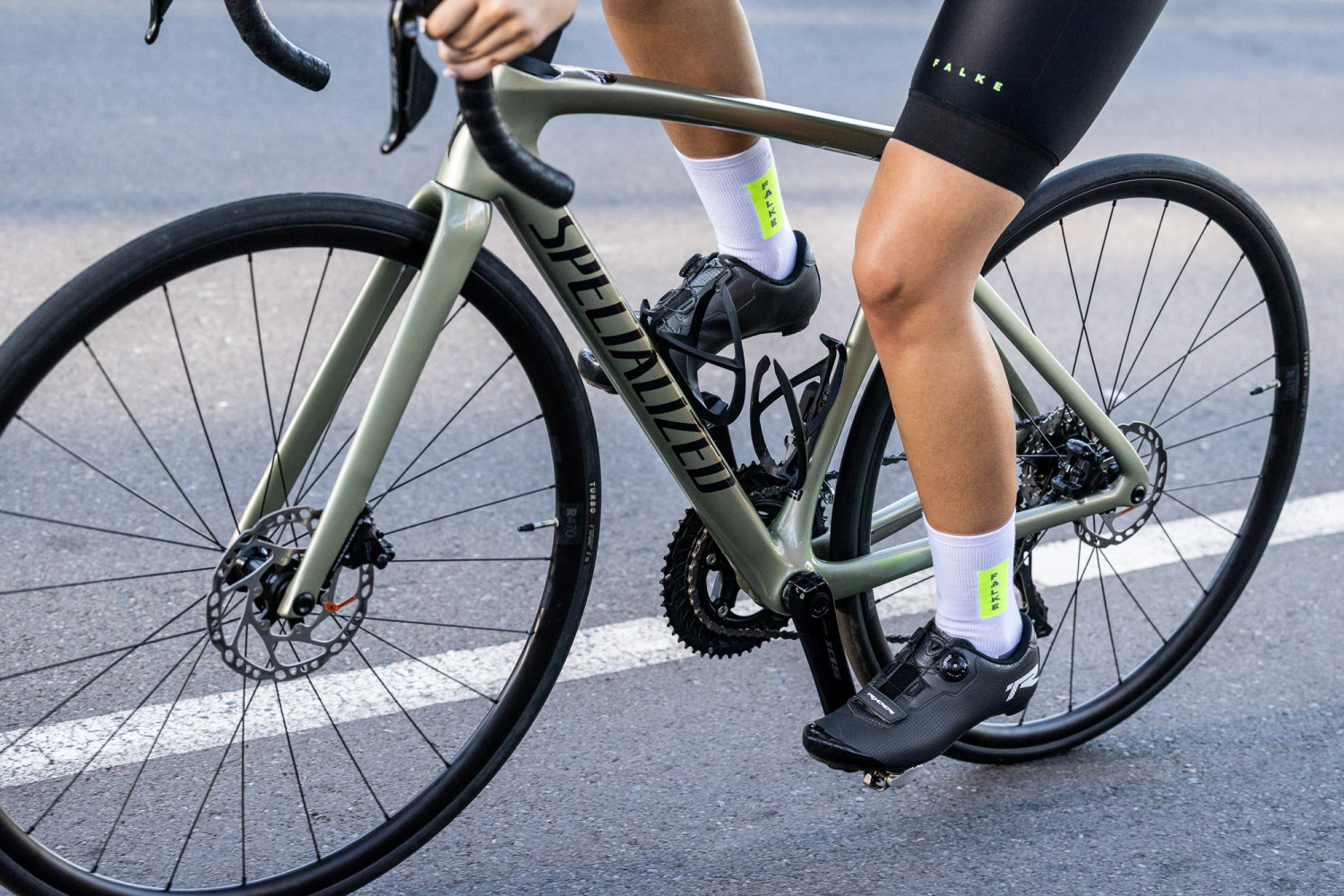 Person cycling on road with Specialized bicycle.