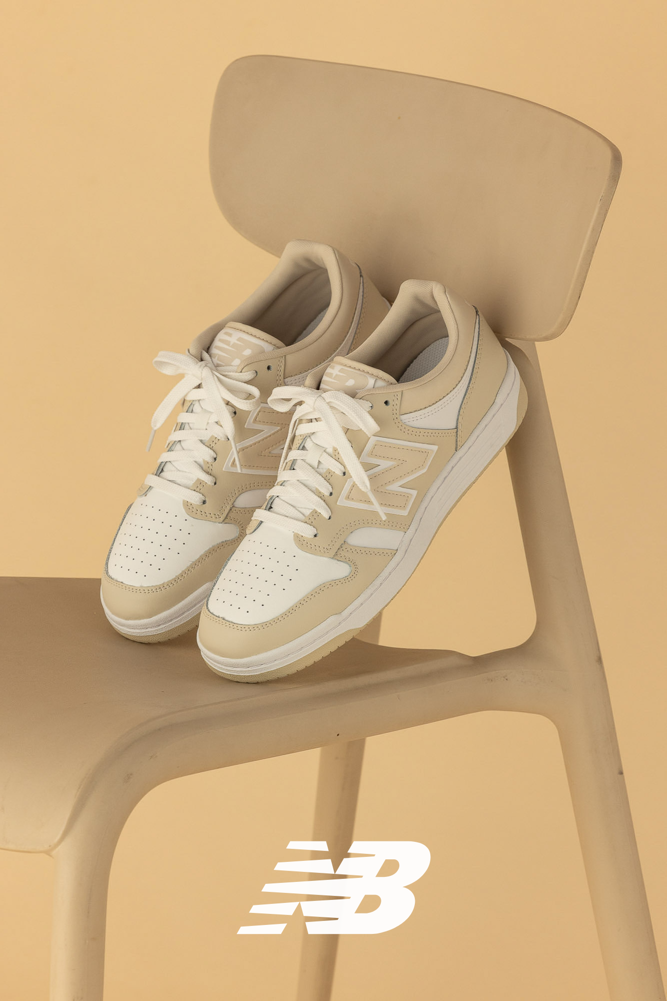 Product photography of the stylish New Balance BB480 sneakers in cream and white.

