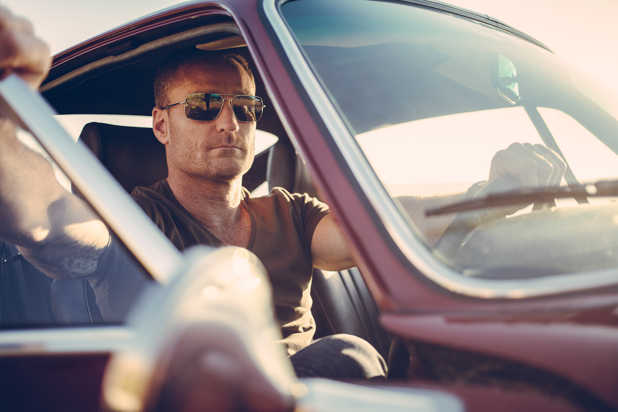 Man in sunglasses driving vintage car by Cape Town photographer Casey Crafford