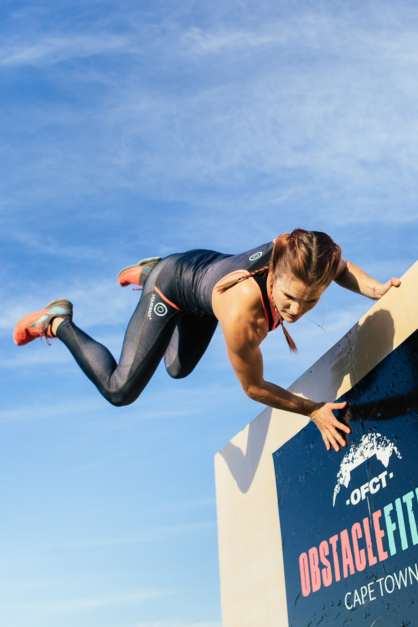 Woman overcoming obstacle in a fitness challenge by Cape Town photographer Casey Crafford